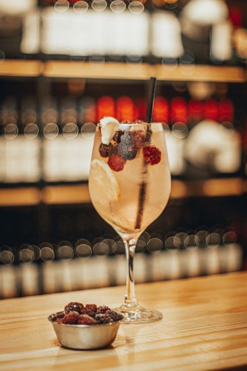 Free A close-up of a refreshing berry cocktail with fruits in a wine glass at a stylish indoor bar. Stock Photo