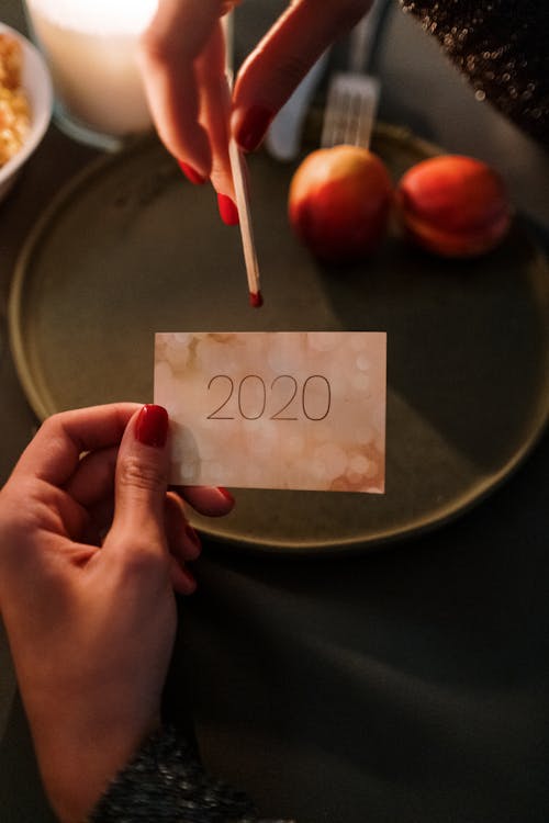 Free Photo of a Person's Hand Holding a 2020 Card and a Match Stick Stock Photo