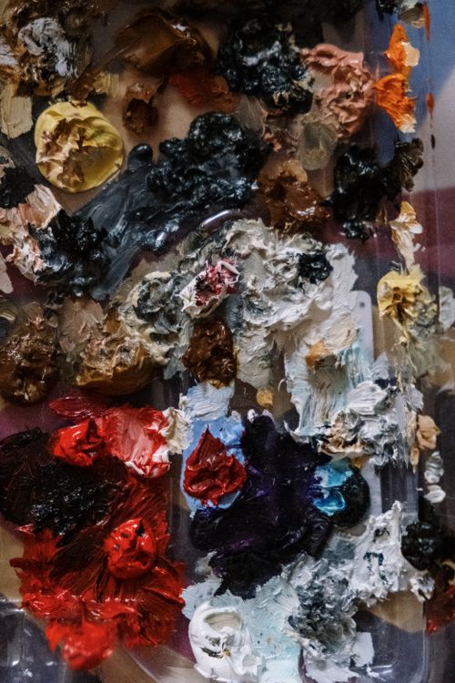 Free Colorful close-up of a mixed oil paint palette with various hues and textures. Stock Photo