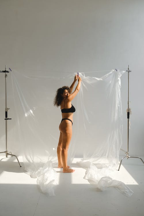 A Woman in Black Bikini Clipping the Plastic on the String