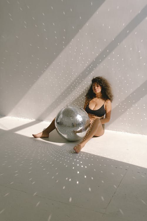 Free Voluptuous Woman Posing with a Disco Ball Stock Photo