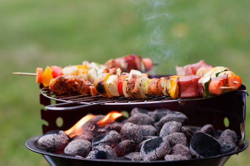 Free Delicious skewers grilling over hot charcoal on a BBQ in an outdoor setting. Stock Photo