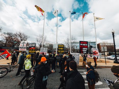 Unrecognizable multiracial dissenters with placards on city roadway