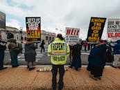 Unrecognizable dissenters with placards on urban pavement