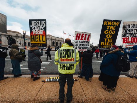 Unrecognizable dissenters with placards on urban pavement