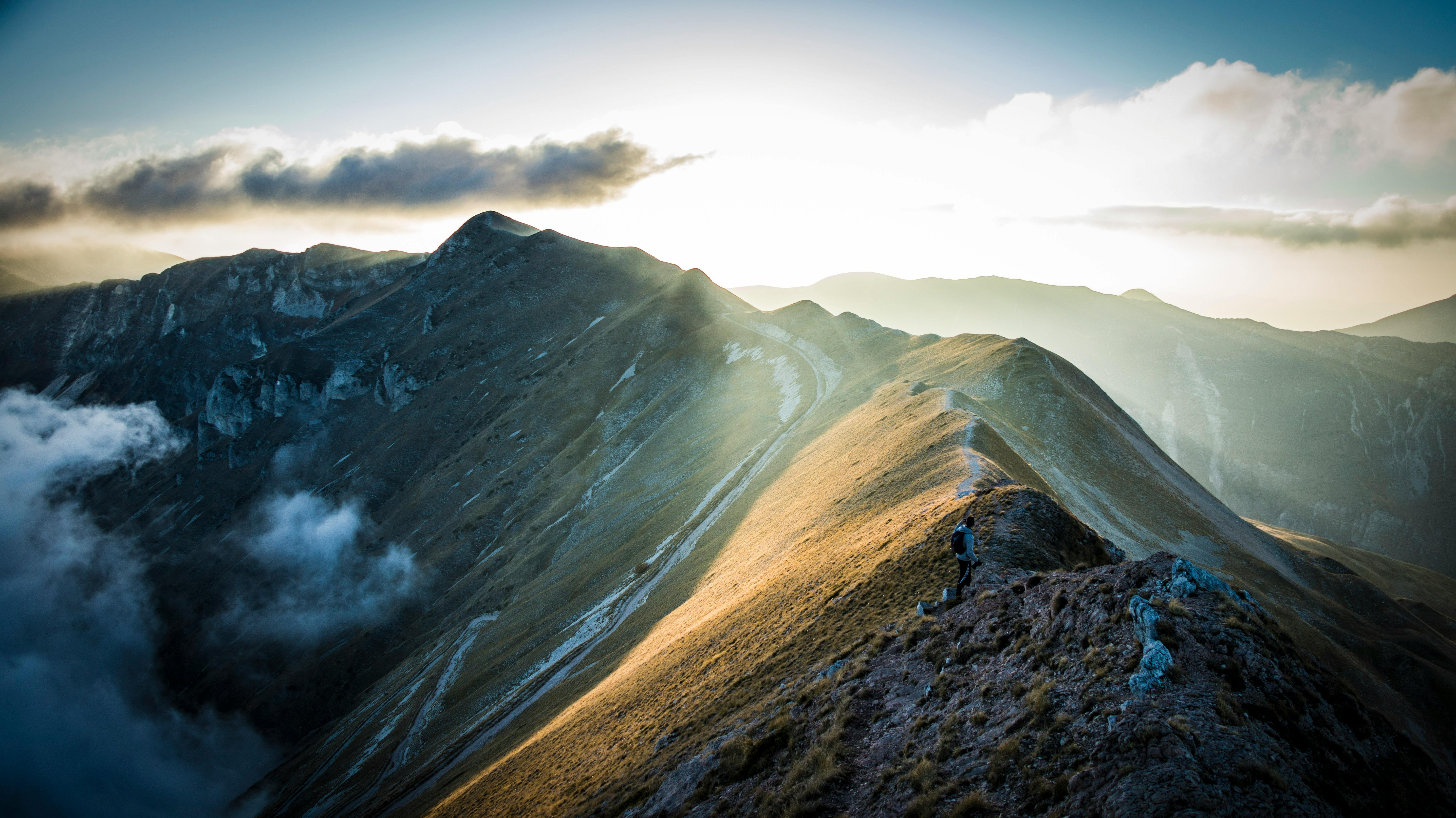 mountain under cloudy sky with sunlight