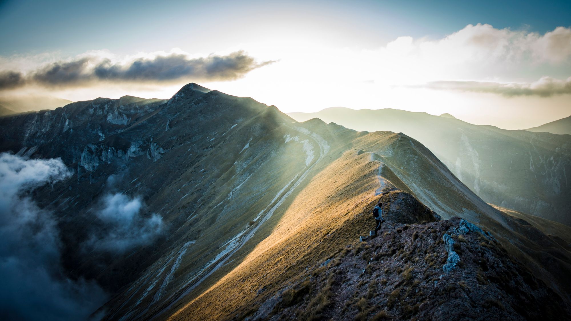 A ridge line catching first light above a bank of cloud — photo by Vittorio Staffolani on Pexels