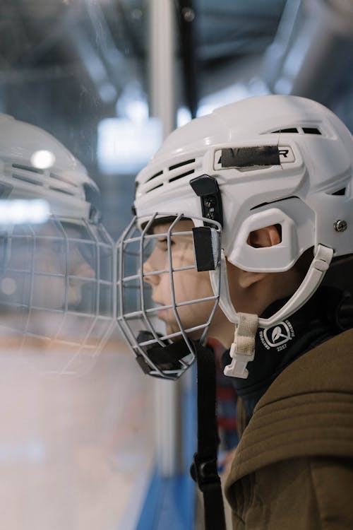 Boy in Helmet Looking at Hockey Game