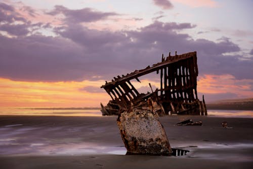Free A Damaged Structure on Seashore at Dusk Stock Photo