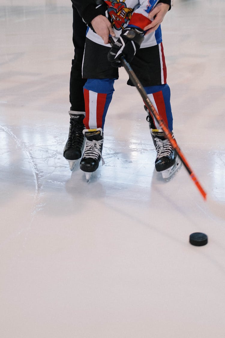 Father Teaching Son To Play Ice Hockey 