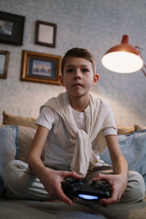 Boy Playing on Game Console with a Wireless Controller