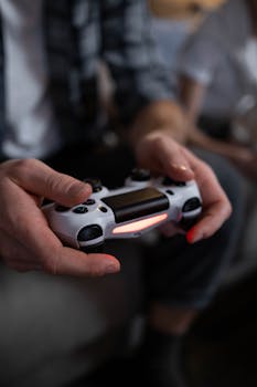 Hands holding a game controller, focusing on gaming experience with shallow focus.