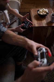 Two individuals play video games in a cozy living room setting, enjoying leisure time.