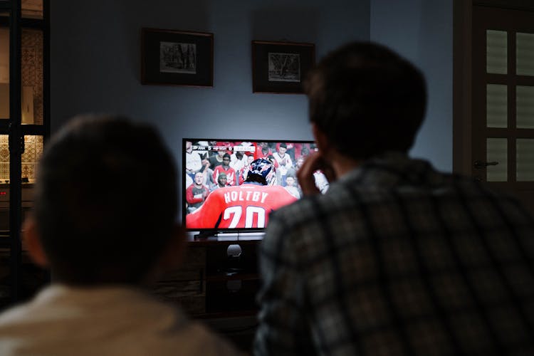 A Father And Boy Watching On The TV 