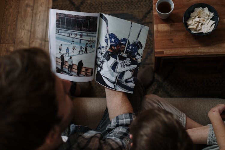 Man Sitting With Ice Hockey Magazine