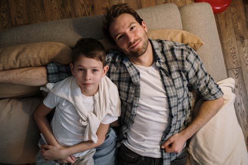 Free Father with Son Lying on the Sofa Looking at the Ceiling Stock Photo