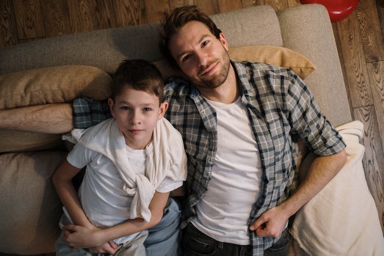 Father With Son Lying On The Sofa Looking At The Ceiling