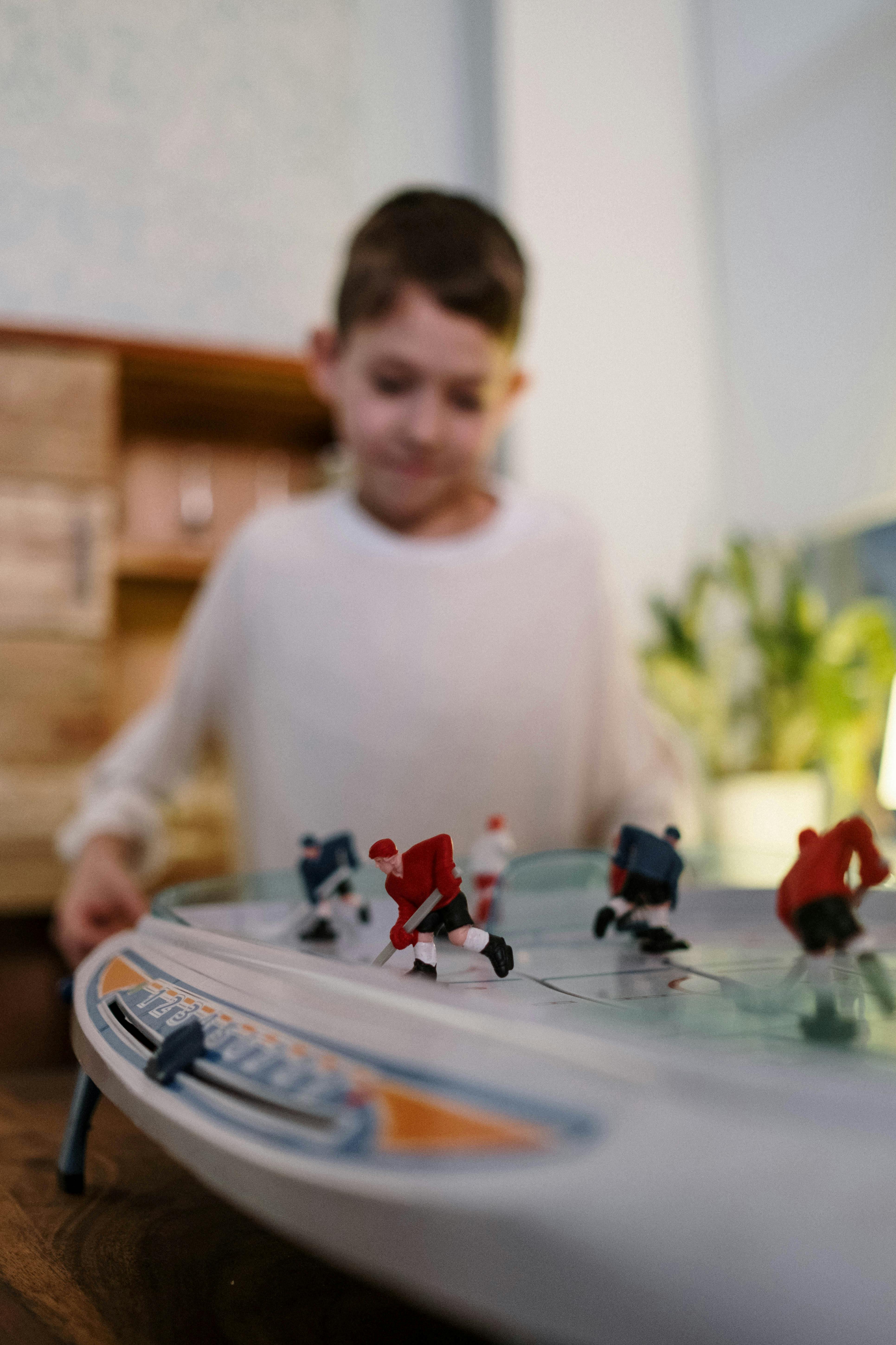 man in white crew neck long sleeve shirt playing red and black toy car