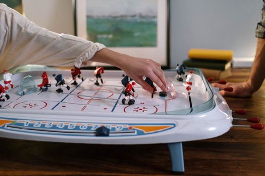 Close-up of hands playing table hockey, showcasing an engaging and fun indoor sport.