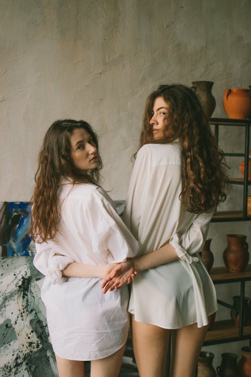 Ladies wearing shirts while holding hands in workshop