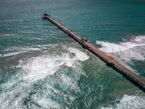 Free Drone Shot of People Walking on a Wooden Dock Stock Photo
