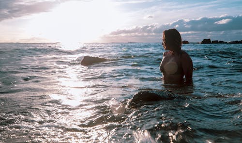 A Woman in a Bikini Looking Towards the Sun