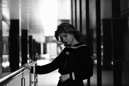 Stylish woman posing in a monochrome urban setting, showcasing elegant fashion.