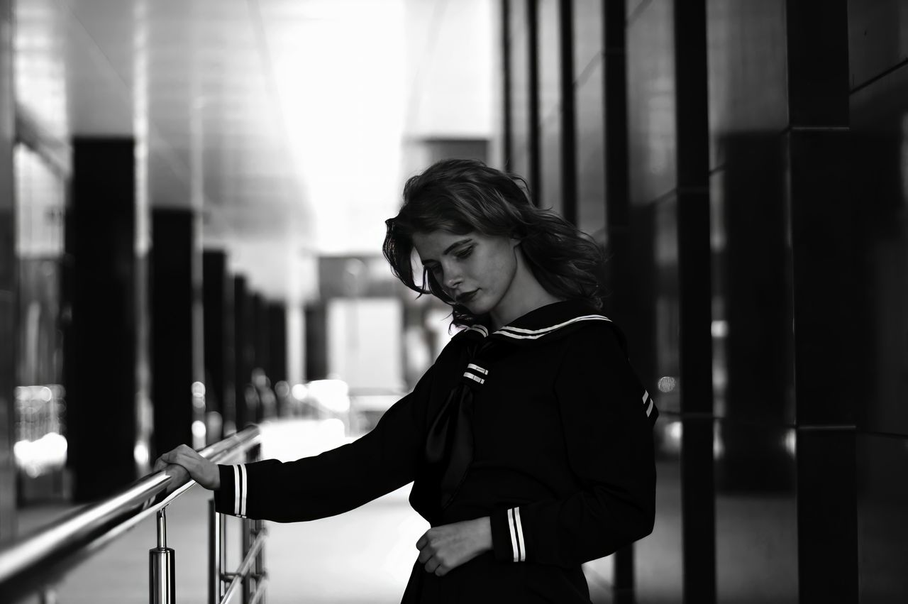 stylish woman posing in a monochrome urban setting showcasing elegant