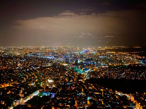 A stunning aerial view of Istanbul at night, showcasing colorful city lights and urban landscape.