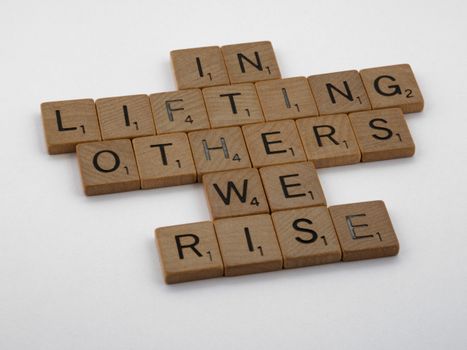 Wooden Scrabble tiles spelling uplifting message on a clean white backdrop.