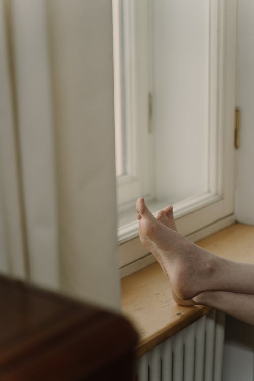 Close-up of Person Sitting with Feet Up on a Windowsill 