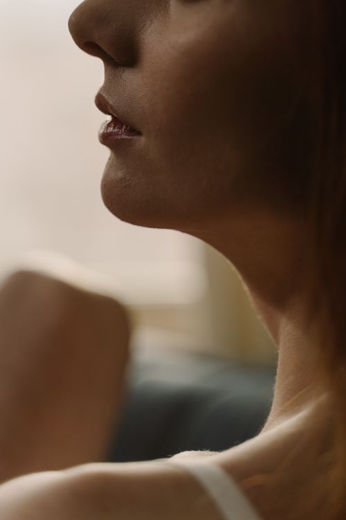 Free Close-up artistic side profile of woman's face highlighting delicate skin and lips. Stock Photo
