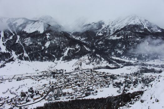 Aerial view of a snowy mountain town nestled in a picturesque valley during winter.
