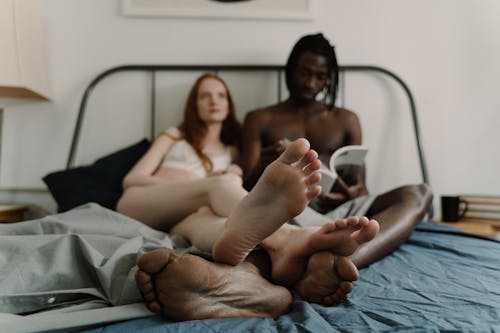 Free  Biracial Couple Lying in Bed Together Stock Photo