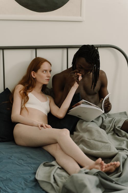Biracial Couple Lying in Bed Together 