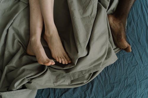 Free Barefoot Couple Lying in Bed Stock Photo