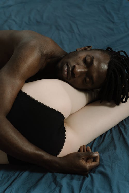 A man sleeps on a sex doll’s thighs