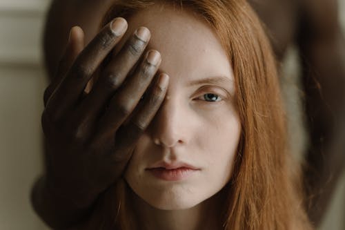 Man Covering Eye of a Woman with His Hand 