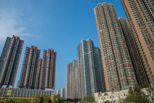 High-rise buildings in Hong Kong under a clear blue sky, showcasing urban density and modern architecture.