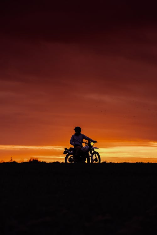 Man Riding Motorcycle during Sunset
