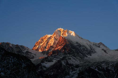 Free Sunset Light at Snowcapped Mountain Peak Stock Photo