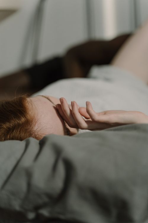 Free A person lying down with hand on head in soft, natural light, creating a cozy and tranquil atmosphere. Stock Photo