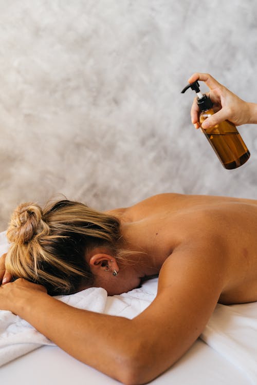 A Shirtless Woman Lying Down on a Bed 