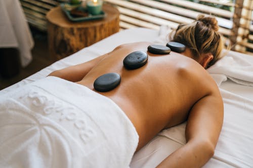 A Topless Woman Lying Down with Basalt at Her Back