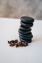 A Stack of Stones on White Surface Near the Star Anise
