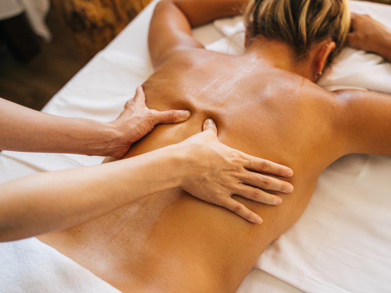 Therapist giving a relaxing full body massage in a warm spa setting