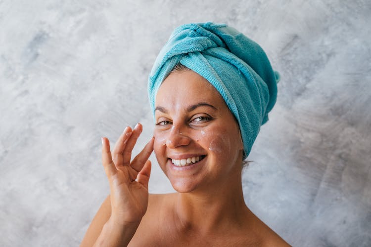 A Smiling Woman With A Towel Wrapped In Her Head