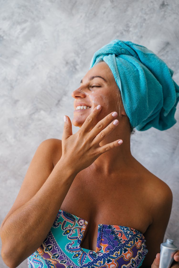 A Woman Applying Moisturizer On Face