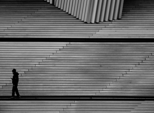 Free A lone figure silhouette on abstract geometric stairs creating a striking urban scene in Paris. Stock Photo