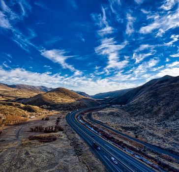 Aerial view of a scenic highway winding through the rolling hills of Huntington, Oregon.